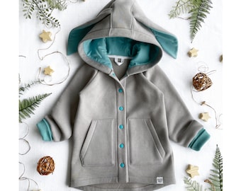 May include: A gray hooded jacket with teal accents and bunny ears. The jacket has a zipper closure and a pocket on the front.