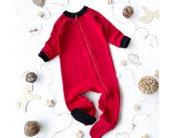May include: Red baby onesie with black trim and a zipper down the front. The onesie has black feet and is made of a soft, comfortable fabric.