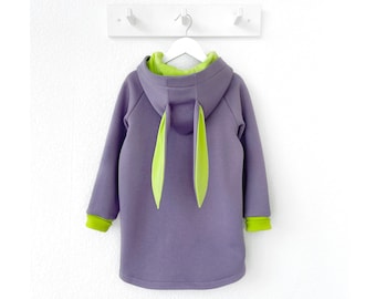 May include: A purple hooded sweatshirt with lime green accents and bunny ears. The sweatshirt has a relaxed fit and is perfect for casual wear.