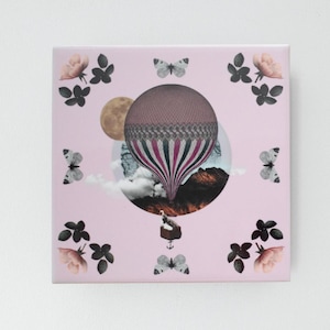 Puede incluir: Una baldosa decorativa cuadrada rosa con un diseño de globo aerostático. El globo es marrón y está rayado con rosa y blanco. La baldosa está decorada con mariposas, flores y una luna.