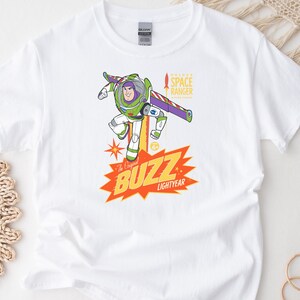 Puede incluir: Camiseta blanca con un gr&aacute;fico colorido de Buzz Lightyear. El dise&ntilde;o incluye el texto "The Original BUZZ LIGHTYEAR" en amarillo y naranja, con "SPACE RANGER" arriba. La camiseta est&aacute; hecha de un material suave y c&oacute;modo.