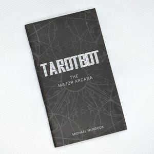 May include: A black booklet titled "TAROTBOT" with "THE MAJOR ARCANA" and the author's name, Michael Murdock, printed on the cover. The cover features a geometric design in a lighter shade of gray.