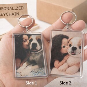 May include: Two personalised keychains with rectangular photo inserts. One shows a person kissing a dog, the other shows a person kissing a puppy. The tag reads "PERSONALIZED KEYCHAIN".