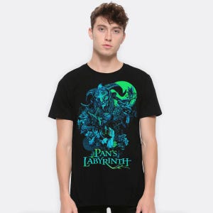 Puede incluir: Camiseta negra con un diseño gráfico de la película "El laberinto del fauno". El diseño incluye una criatura con cuernos, elementos florales y el título de la película en verde y azul verdoso. La camiseta es de material suave.
