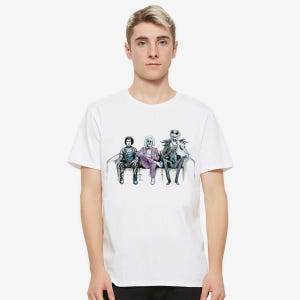 K&ouml;nnte beinhalten: Wei&szlig;es T-Shirt mit einem Grafikdruck von drei Figuren aus dem Film "Nightmare Before Christmas" auf einer Couch. Die Figuren sind Jack Skellington, Sally und Oogie Boogie.