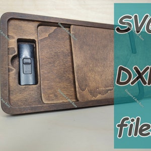 以下が含まれることがあります： USB ドライブ用の切り抜きのある木製の箱。箱は濃い茶色の木でできており、自然な木目仕上げです。USB ドライブは黒で、銀色のボタンが付いています。箱には「SVG DXF ファイル」というテキストがラベル付けされています。