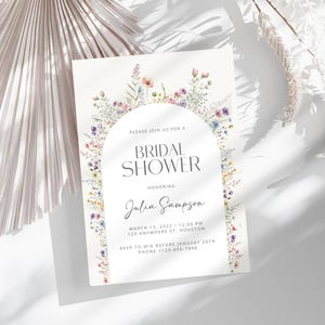 May include: A floral bridal shower invitation featuring a watercolour illustration of a flower arch. The invitation includes the text "Please join us for a Bridal Shower honouring Julia Sampson" and the date, time, and location of the event. RSVP information is also included.