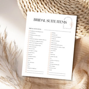 K&ouml;nnte beinhalten: Eine druckbare Checkliste f&uuml;r den Hochzeitstag einer Braut. Die Checkliste tr&auml;gt den Titel "Bridal Suite Items" und enth&auml;lt Artikel wie Hochzeitskleid, Schuhe, Schmuck und Accessoires. Die Checkliste ist in zwei Spalten unterteilt, eine f&uuml;r die pers&ouml;nlichen Gegenst&auml;nde der Braut und eine f&uuml;r die Hochzeitsessentials der Braut.