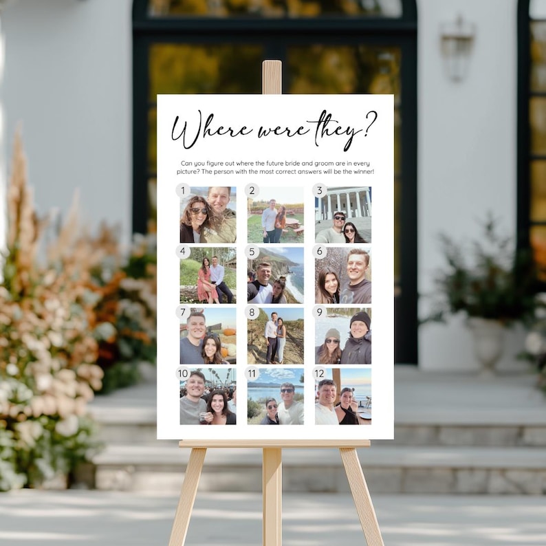 May include: A white sign on a wooden easel with the text "Where were they?" in black script. The sign features 12 small photos and prompts guests to guess the locations in the pictures. A fun game for a wedding or engagement party.