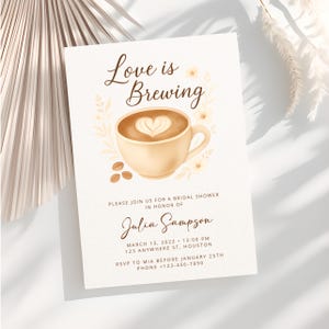 May include: A bridal shower invitation with the text "Love is Brewing" above a coffee cup illustration. The invitation includes details for Julia Sampson's bridal shower, including the date, time, and location. The design features floral accents.