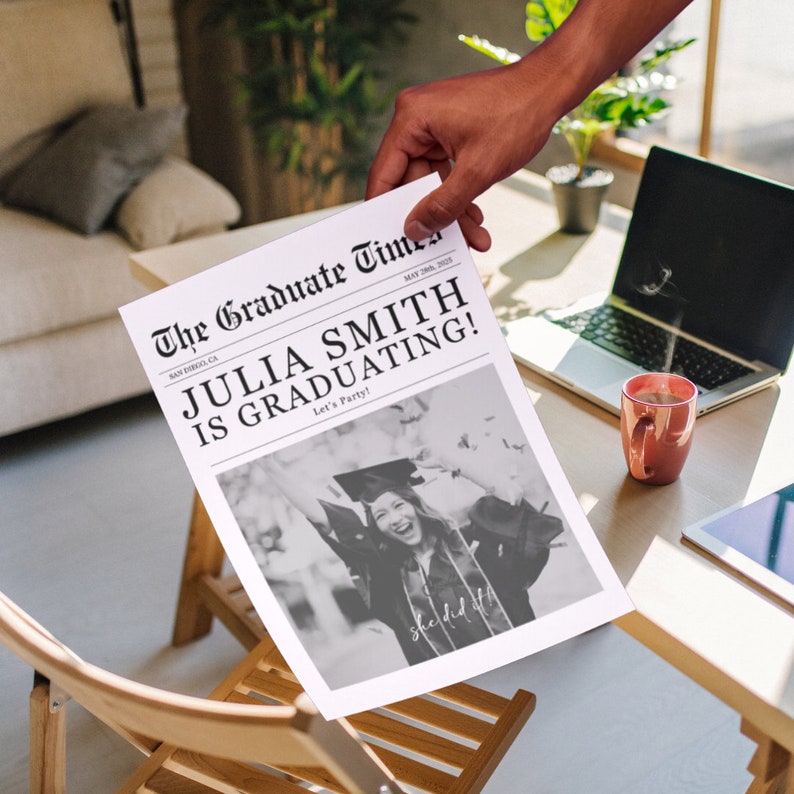 May include: A black and white newspaper headline announcing "Julia Smith is Graduating!" with a photo of a person wearing a graduation cap and gown. The headline is in a vintage newspaper style.