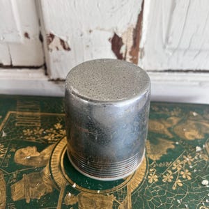 Puede incluir: Una taza de cer&aacute;mica blanca con un asa negra y el texto "But First, Coffee" en negrita negra. La taza se encuentra sobre un fondo neutro, resaltando su dise&ntilde;o simple.