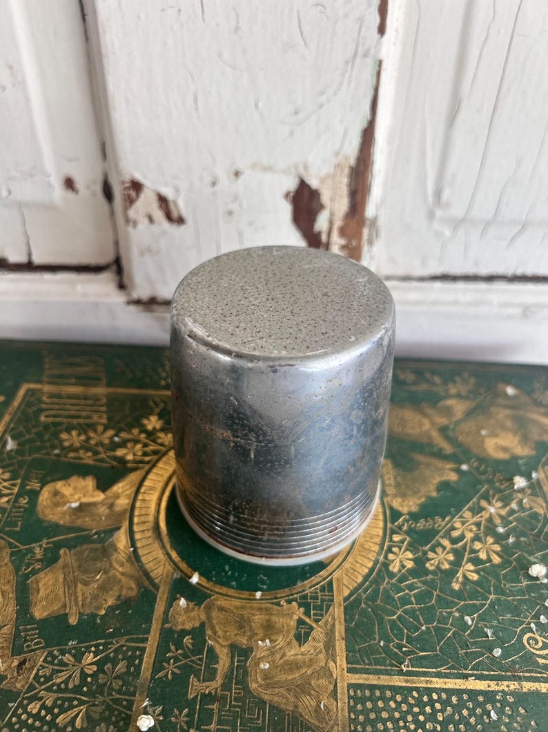 Puede incluir: Una taza de cer&aacute;mica blanca con un asa negra y el texto "But First, Coffee" en negrita negra. La taza se encuentra sobre un fondo neutro, resaltando su dise&ntilde;o simple.