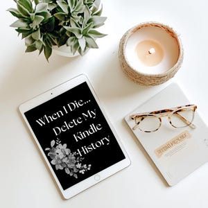 May include: A white tablet with a black screen displaying the text "When I Die... Delete My Kindle History". The tablet is on a white surface with a candle in a woven basket and a notebook with glasses on top.