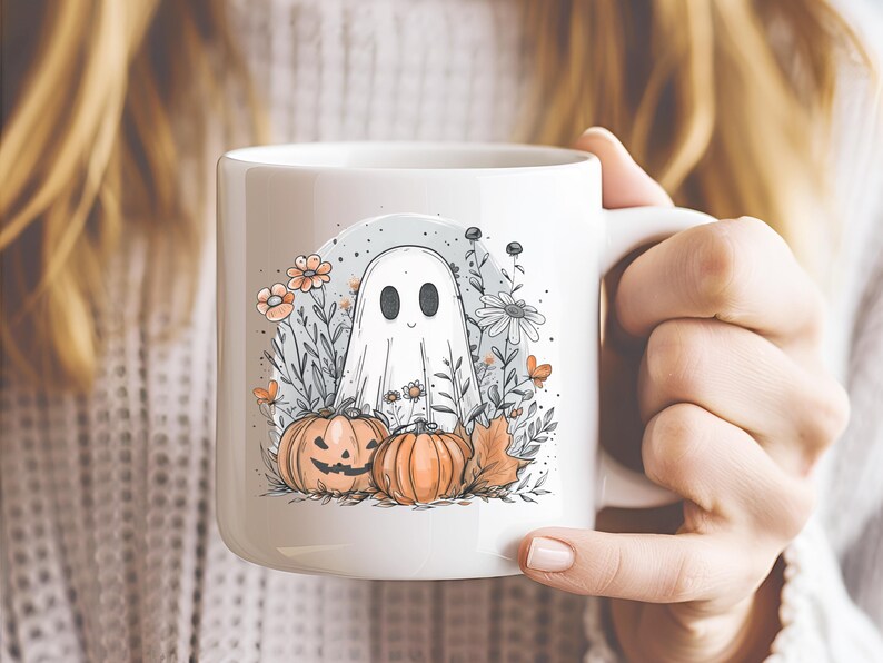 May include: White ceramic mug featuring a Halloween-themed illustration. The design includes a friendly ghost, pumpkins, flowers, and foliage in shades of orange, gray, and white. The mug has a standard handle and a glossy finish, perfect for seasonal beverages.