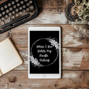 May include: A black and white image on a tablet screen with a floral wreath and the text "When I Die Delete my Kindle History".