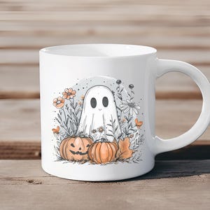 May include: White ceramic mug featuring a Halloween-themed design. The illustration includes a friendly ghost, pumpkins, flowers, and leaves. The design is in shades of orange, gray, and white, perfect for the fall season.