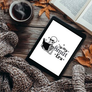 May include: A black and white illustration of a skeleton reading a book with the text "In my Smut Era" on a white background.