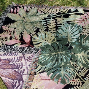 Botanical Woven Throw used as a picnic blanket with two-sided woven design. Black background. Great gift for plant mom, gift for Grandma, gift for Mom, Mother's Day gift, use as a throw, picnic blanket, etc.