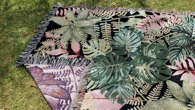 Botanical Woven Throw used as a picnic blanket with two-sided woven design. Black background. Great gift for plant mom, gift for Grandma, gift for Mom, Mother's Day gift, use as a throw, picnic blanket, etc.