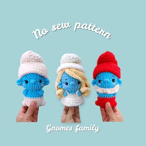 Könnte beinhalten: Drei handgefertigte Häkelzwerge in Blau, Weiß und Rot. Jeder Zwerg hat eine andere Mütze und ein anderes Outfit. Der Text "No sew pattern" und "Gnomes family" sind auf dem Bild geschrieben.