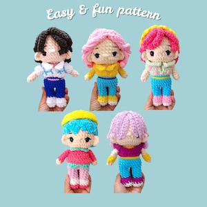 May include: Five handmade crochet dolls with different hair colors and outfits. Each doll has a unique color scheme, including pink, yellow, blue, and purple. The dolls are held in hands against a light blue background. Text at the top reads "Easy & fun pattern."
