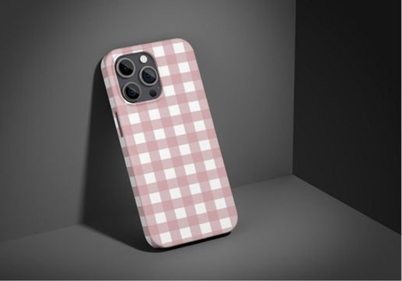 Może przedstawiać: Etui na telefon w kratkę w kolorze r&oacute;żowym i białym do iPhone'a.