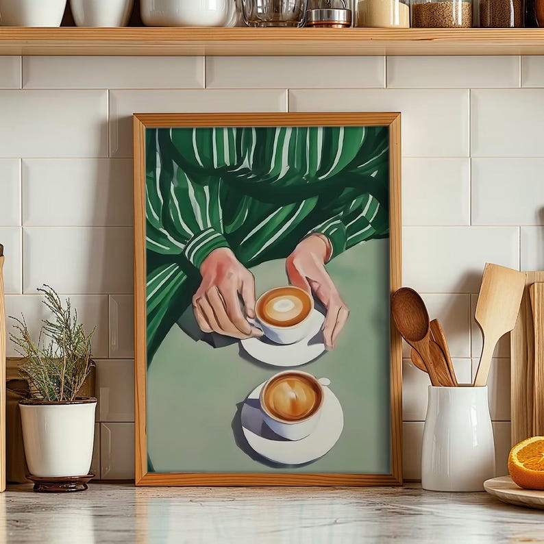 May include: A framed illustration of two cups of coffee with a green and white striped shirt in the background.
