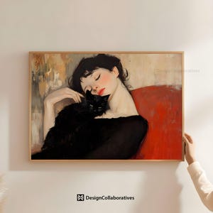 Puede incluir: Una impresión artística enmarcada representa a una mujer con los ojos cerrados, apoyada contra una superficie roja, abrazando a un gato negro. La obra de arte tiene una estética vintage con colores suaves y un marco de madera. La impresión está etiquetada como "DesignCollaboratives".