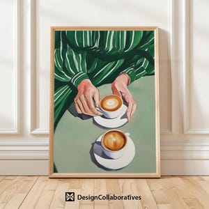 May include: Two cups of coffee with foam on top, sitting on white saucers on a green surface. A person's hands are visible in the background, wearing a green and white striped shirt.