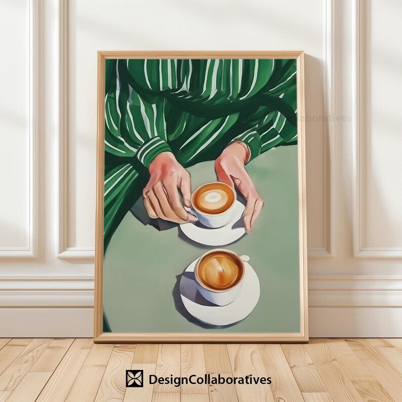 May include: Two cups of coffee with foam on top, sitting on white saucers on a green surface. A person's hands are visible in the background, wearing a green and white striped shirt.
