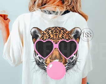 May include: A white t-shirt with a graphic of a leopard wearing pink heart-shaped sunglasses and blowing a pink bubble. The leopard has brown and black spots.
