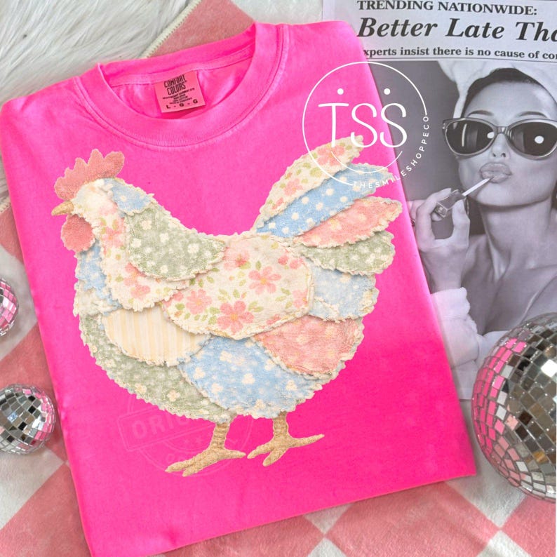 May include: A bright pink Comfort Colors sweatshirt featuring a patchwork chicken design. The chicken is made of various floral and polka dot fabrics in pastel colors. The shirt has a crew neck and long sleeves. The text "ORIGINAL" is visible on the bottom of the shirt.