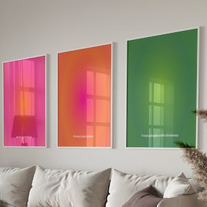 Puede incluir: Un interior de sala de estar con un sofá blanco, una mesa de café redonda de madera y tres impresiones de arte abstracto enmarcadas en la pared. Las impresiones son en tonos de rosa, naranja y verde. El texto en las impresiones dice "Treat yourself with grace", "Treat your mind with peace", y "Treat people with kindness".