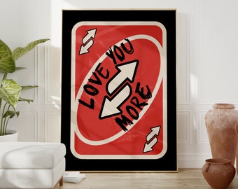 May include: A red and white card with the text "Love You More" written on it in black marker. The card is a parody of the popular card game "Cards Against Humanity".