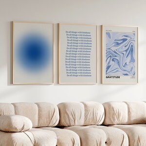 Op de afbeelding: Drie ingelijste prints met een witte achtergrond. De linker print heeft een blauwe gradi&euml;nt. De middelste print heeft de tekst "Do all things with kindness" 18 keer herhaald. De rechter print heeft een abstract marmerpatroon in blauw en wit en de tekst "GRATITUDE".