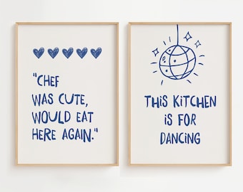 May include: Two framed prints with white backgrounds and blue text. The left print has five blue hearts and the text "CHEF WAS CUTE, WOULD EAT HERE AGAIN.". The right print has a blue disco ball with stars and the text "THIS KITCHEN IS FOR DANCING".
