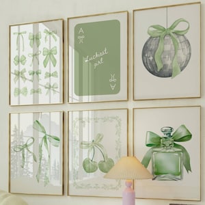 May include: Six framed art prints with gold frames. The prints feature watercolor designs of bows, a playing card, a disco ball, cherries, and a perfume bottle, all in shades of green. The text "Luckiest girl" is on the playing card.