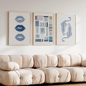 May include: Three framed prints with a light wood frame. One print features three blue lip prints. Another print displays various matchbox designs. The third print shows two blue leopard illustrations on a white background.