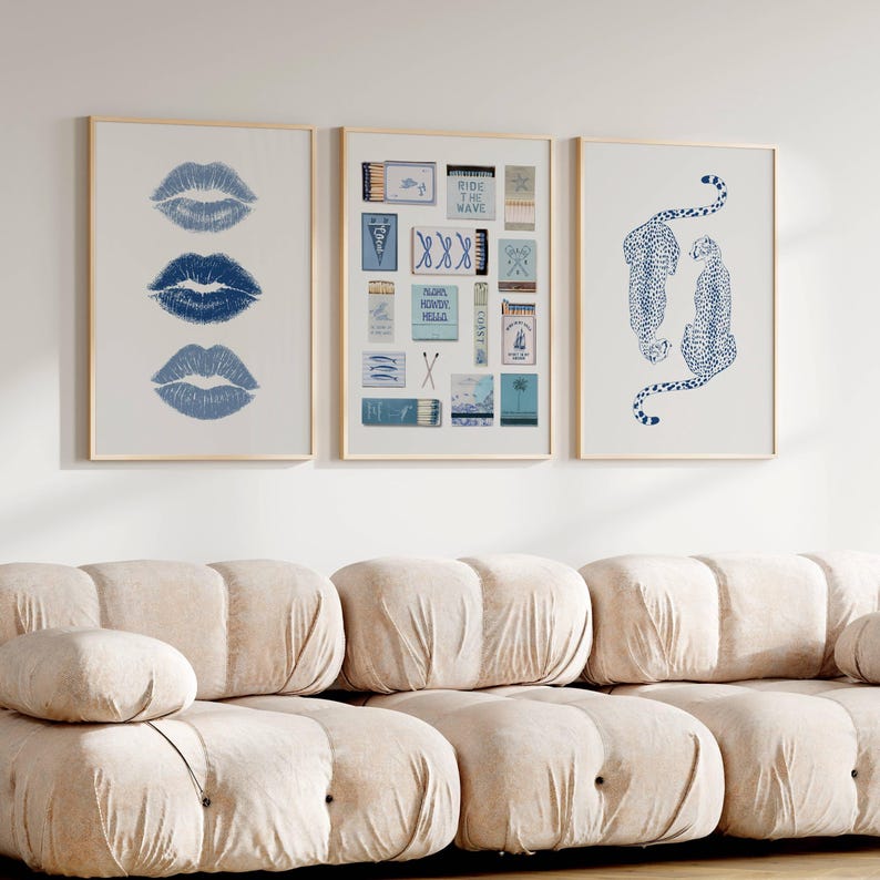 May include: Three framed prints with a light wood frame. One print features three blue lip prints. Another print displays various matchbox designs. The third print shows two blue leopard illustrations on a white background.