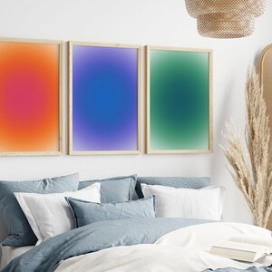 Peut inclure: Trois impressions d'art abstrait encadr&eacute;es avec des fonds de couleur d&eacute;grad&eacute;s. Les impressions sont dans une chambre &agrave; coucher avec un lit, des oreillers et une lampe.