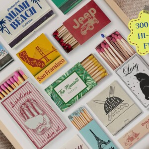 May include: A collection of matchboxes with various designs, including a red matchbox with the word "Jeep" in white letters, a blue matchbox with the words "Sardines in olive oil" in white letters, and a green matchbox with the words "The Marriott Hotels" in white letters.