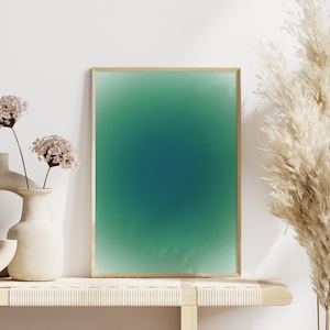 Peut inclure: Une impression d&eacute;grad&eacute;e verte et bleue encadr&eacute;e avec un cadre en bois clair repose sur une &eacute;tag&egrave;re en bois clair avec deux vases en c&eacute;ramique avec des fleurs s&eacute;ch&eacute;es et une plante de gramin&eacute;es s&eacute;ch&eacute;es.