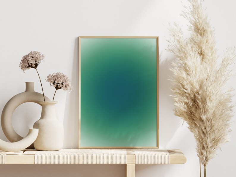 Peut inclure: Une impression d&eacute;grad&eacute;e verte et bleue encadr&eacute;e avec un cadre en bois clair repose sur une &eacute;tag&egrave;re en bois clair avec deux vases en c&eacute;ramique avec des fleurs s&eacute;ch&eacute;es et une plante de gramin&eacute;es s&eacute;ch&eacute;es.
