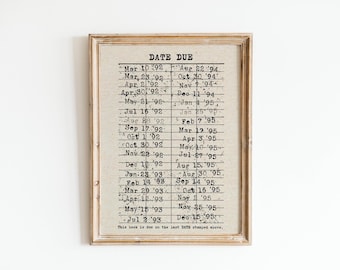 May include: A framed print with a vintage style calendar listing dates due from March 10, 1992 to December 15, 1995. The text "DATE DUE" is at the top of the calendar. The text "This book is due on the last DATE stamped above." is at the bottom of the calendar.