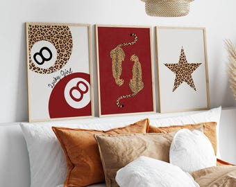 May include: Three framed art prints with a leopard print theme. One print features a leopard print eight ball with the text "Lucky Girl". Another print shows two cheetahs on a red background. The third print has a leopard print star.