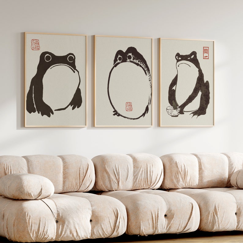 May include: Three framed black and white ink drawings of frogs. The frogs are in different poses, one is sitting, one is holding a bowl, and one is in a circle.