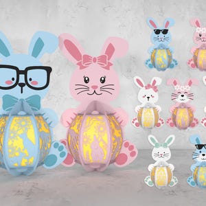May include: A set of nine Easter bunny decorations, each holding a glowing egg. The bunnies are in various colors, including pink, blue, and white. Some bunnies wear sunglasses, while others have flowers in their hair.