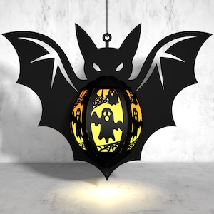 May include: A black bat silhouette with a glowing orange and yellow sphere hanging from it. The sphere is decorated with a spiderweb design and several ghost figures.