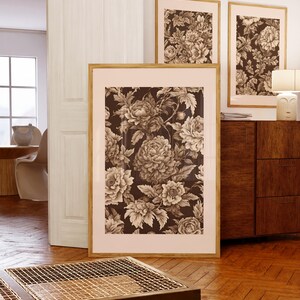 以下が含まれることがあります： 茶色の色合いの花柄が描かれた額装されたプリントが3枚。プリントは白い壁に木製のドレッサーの上に飾られています。